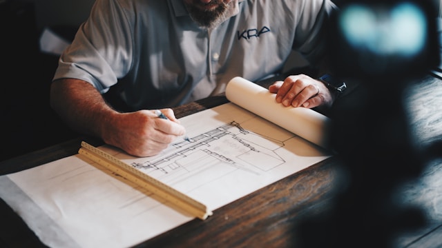 An architect working on a draft with a pencil and a ruler.